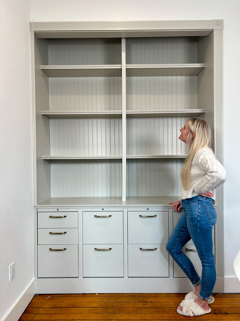 Haley standing next to a DIY custom build in shelf