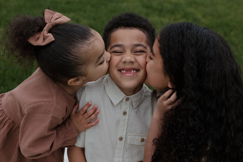 siblings kissing each other's cheek