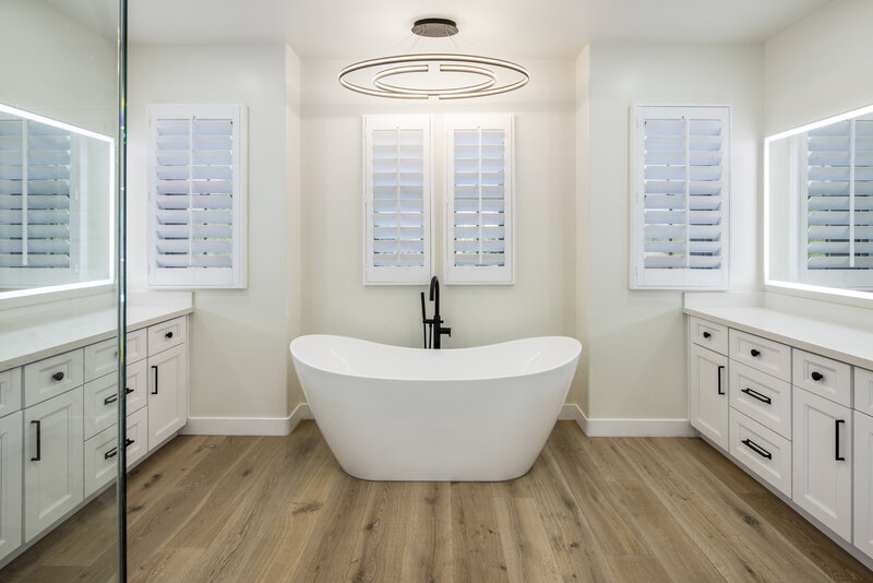 Remodeled master bath with engineered hardwood floors, white cabinets and marble countertops