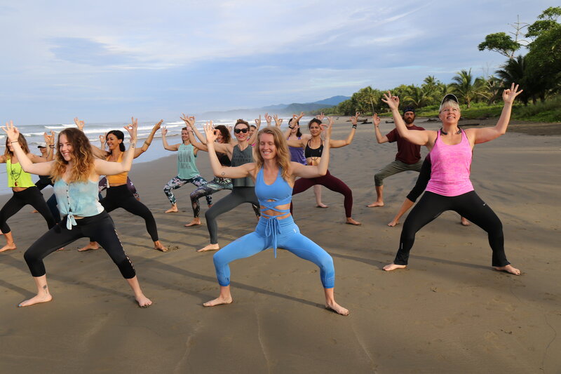 YTT Trainees practicing Goddess pose at the beach in Costa Rica