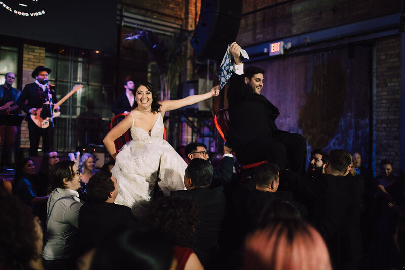Newlyweds lifted in chairs during Hora dance at Milwaukee wedding