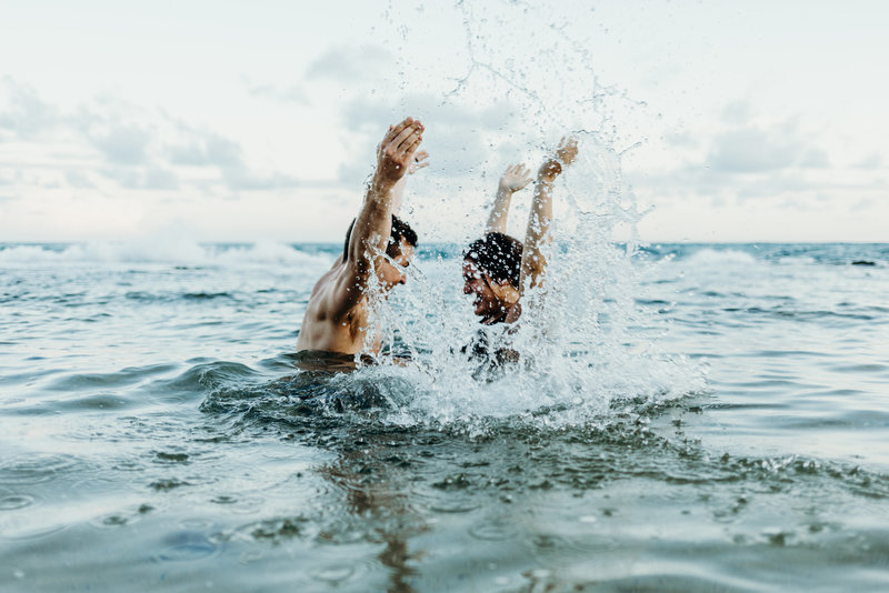 man & woman splashing in ocean