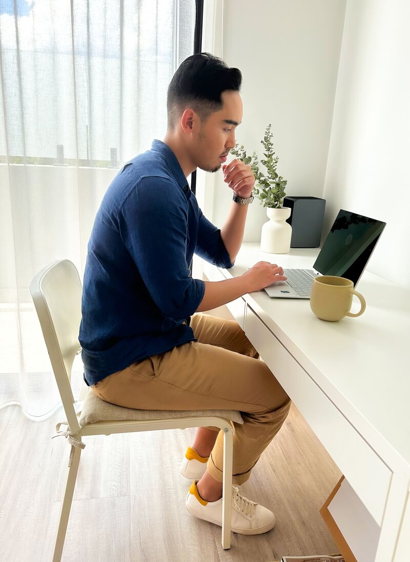 Aleczander Gamboa, a man, typing on his laptop while working in his office