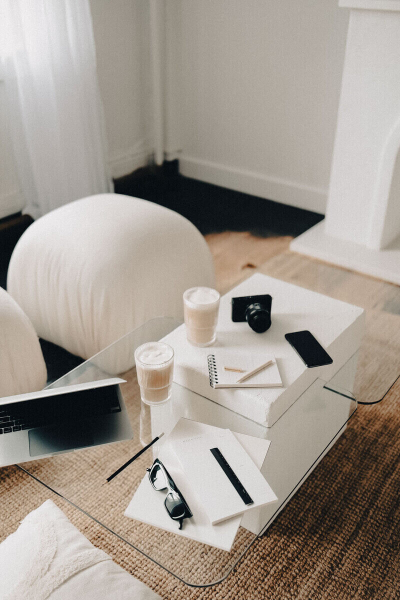 A coffee table arrangement with a laptop, coffee, and a book, showcasing a comfortable and productive workspace.