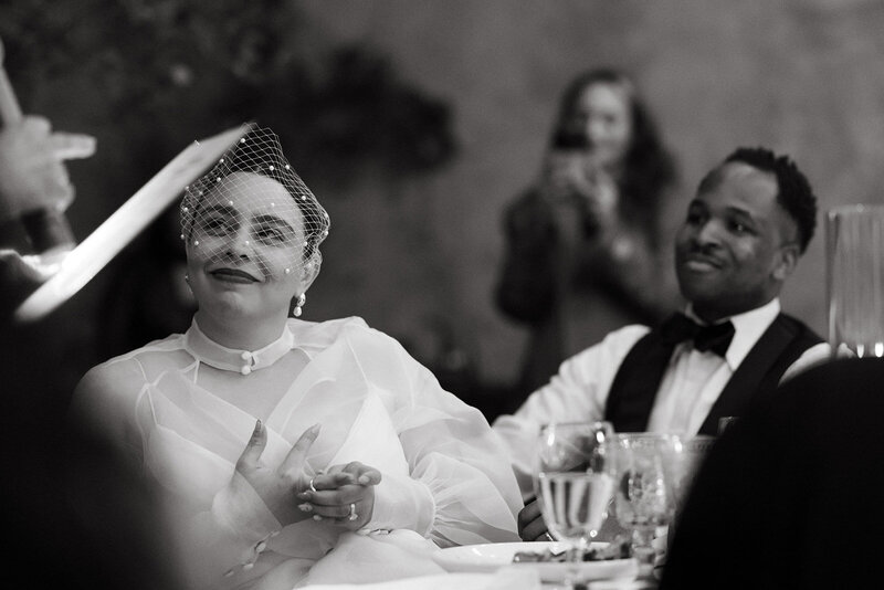 black and white photo of stunning couple at their wedding reception during speeches