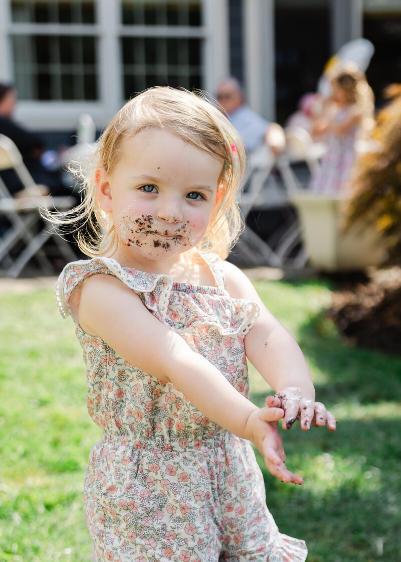 Girl with cake-covered face at a family celebration