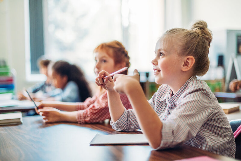 girl in classroom sitting at desk learning