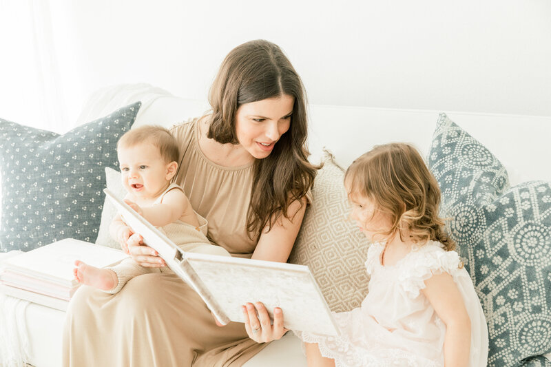 Mother with two children looking at baby book