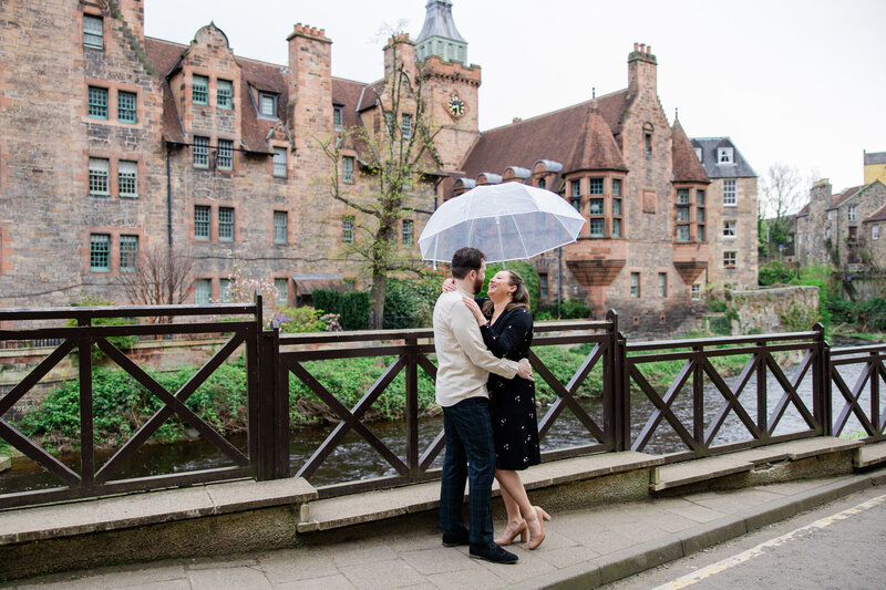 engaged couple smiles under umbrella