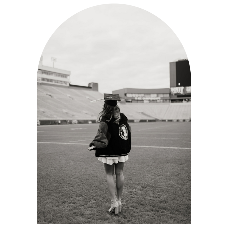 Senior girl with her cap walking on the football field