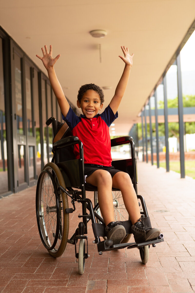 happy-disabled-schoolboy-with-arms-up-looking-at-c-2023-11-27-05-36-11-utc