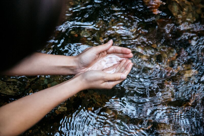 hands gathering water at a greek