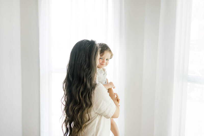 oklahoma mother holding her son in a historic home in herritage hills captured by an okc family photographer