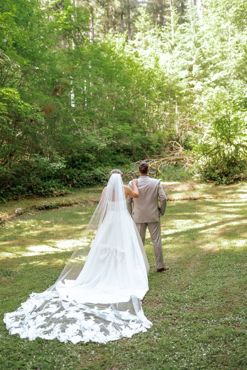 real bride Madelynn wearing a custom lace bridal veil with vintage heirloom lace while posing in the forest