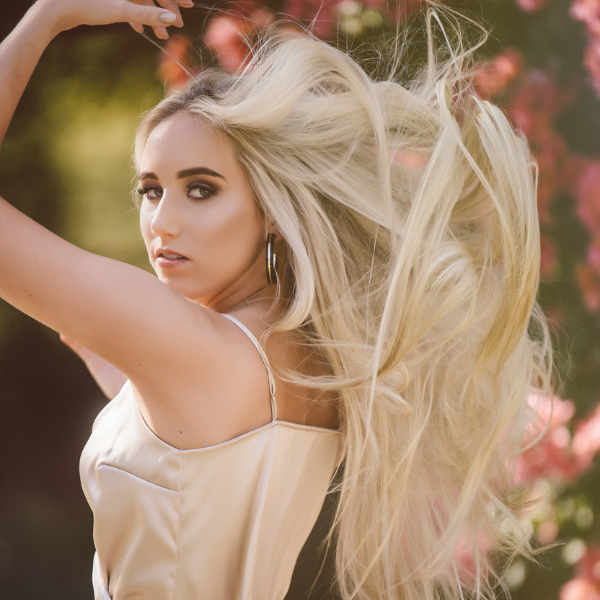 girl with long blond hair floral background senior portrait