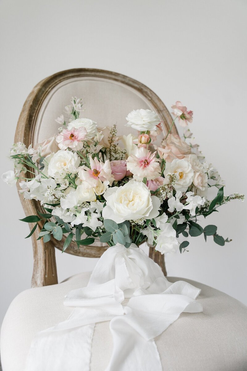 Columbus branding photos with a bouquet sitting on a cream and wood chair