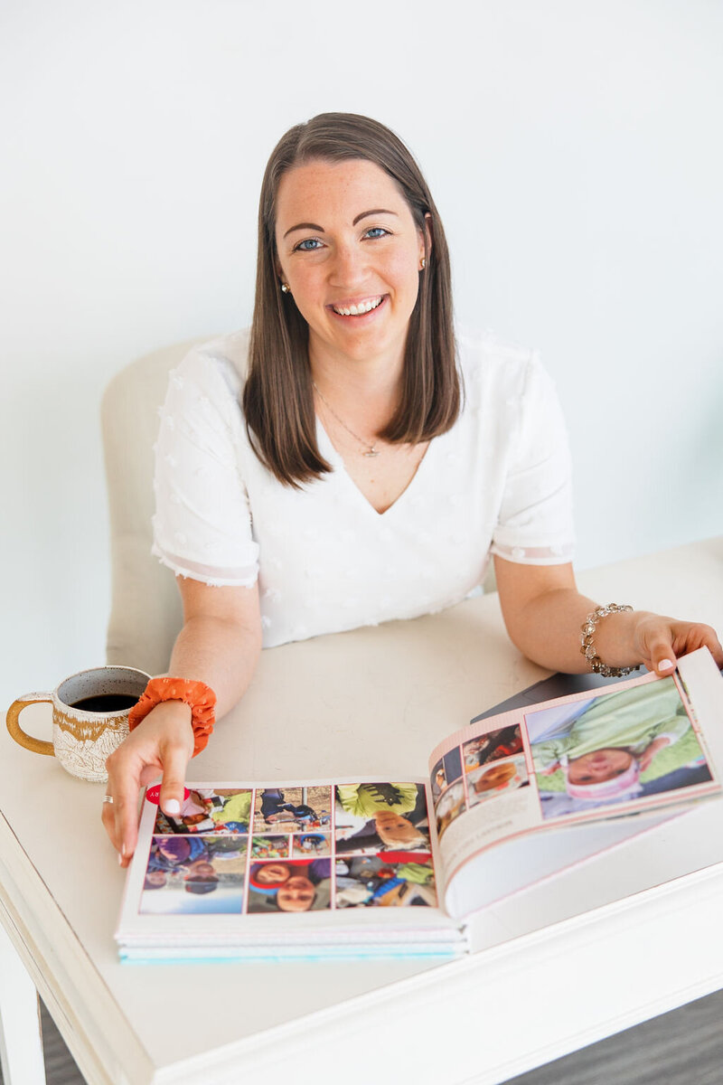 Erin Thompson smiling and holding a family yearbook