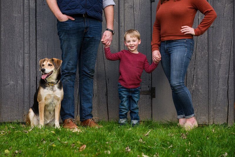 boy posing with a dog and grownup legs