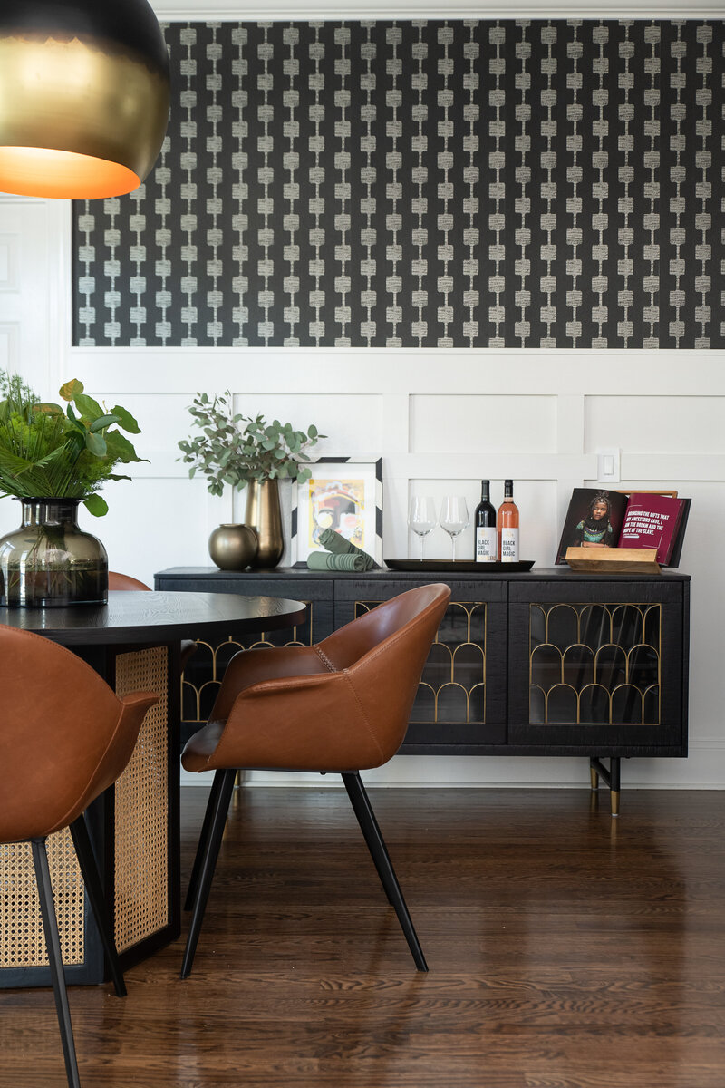 a dining room with a modern black, gold, and orange theme