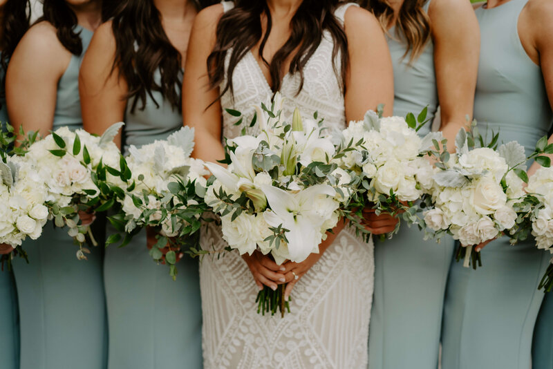 Wedding photos of bride and bridesmaids holding up their bouquets.