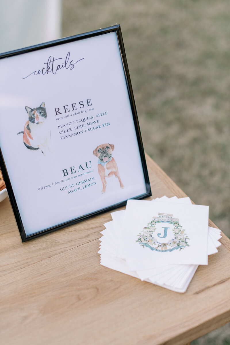 A wedding cocktail sign with watercolor pet portraits by artist Alicia Betz of The Welcoming District.