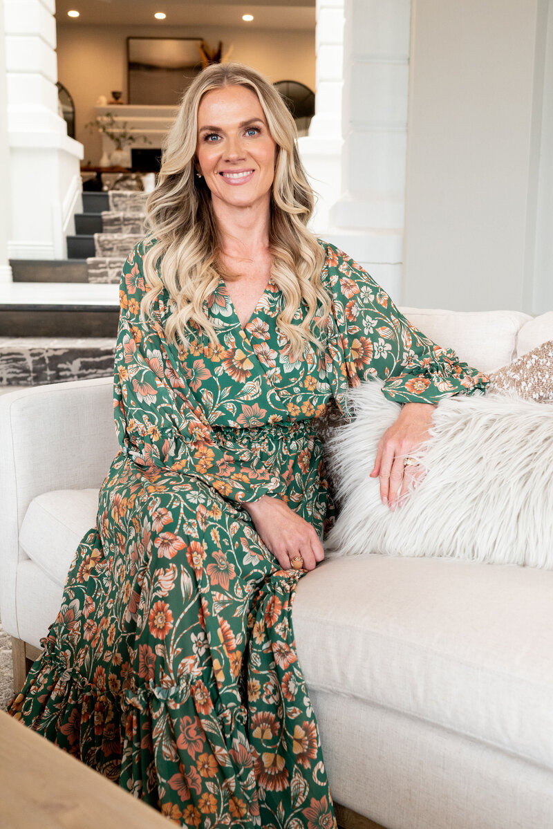 woman sitting on couch with green floral dress