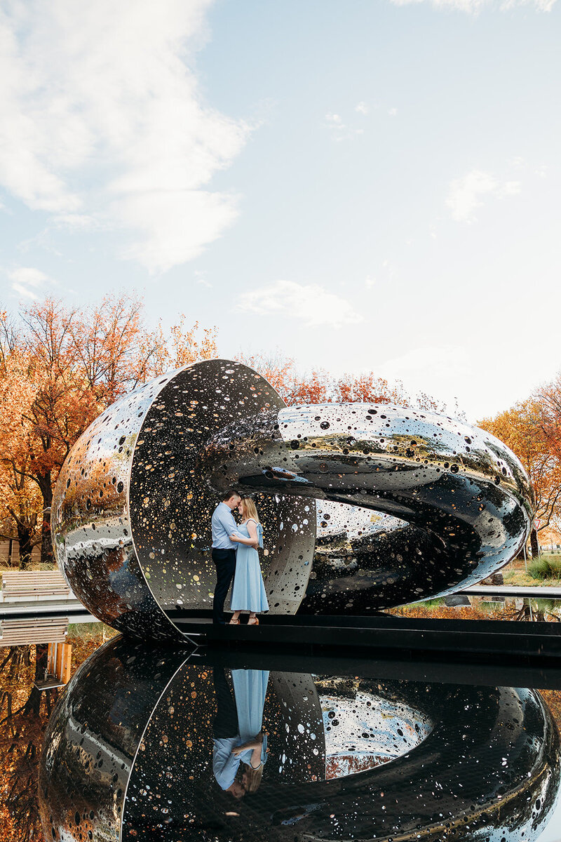 Engaged couple standing in the Ouroboros sculpture at the National Gallery of Australia (NGA) in Canberra ACT. Photo by Acacia & Grace