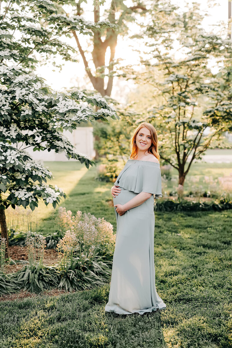 mom in blue maternity dress in Forest Park St Louis in spring