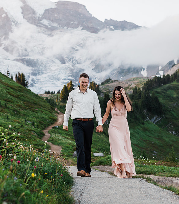 A couple strolls along a trail at dusk during their wildflower adventure engagement session at Mt Rainier National Park with adventure elopement photographer Amy Galbraith