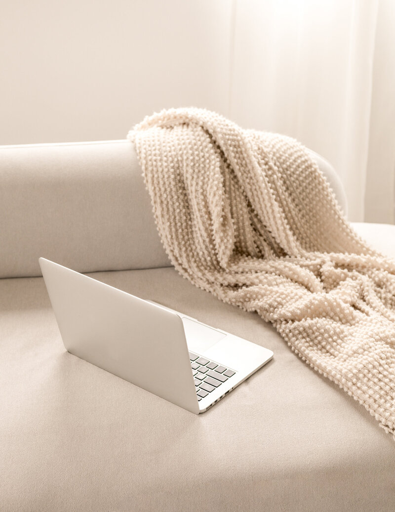 A laptop on a serene creative space on a couch