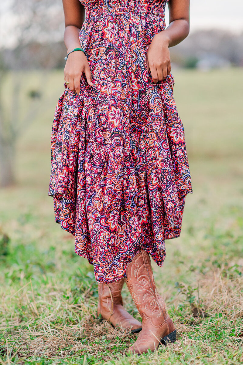 close up of a girl wearing a pink dress and cowgirl boots