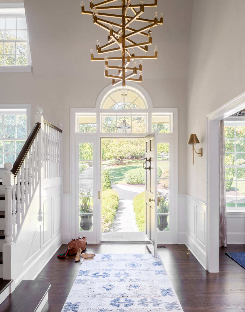 bright white entry way with dark wood floor and door open