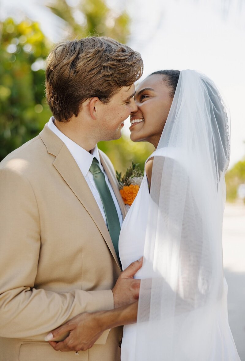 couple leans in for a kiss during wedding portraits in south florida