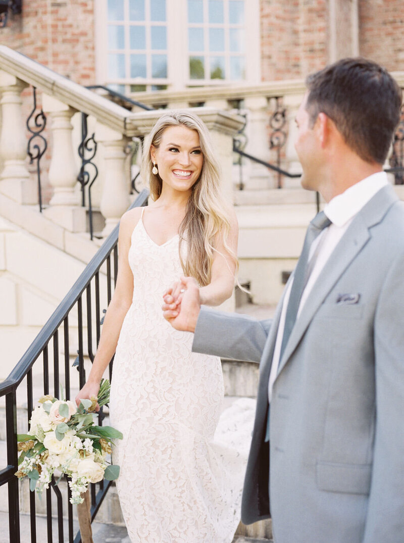 bride and groom holding hands while walking down the steps