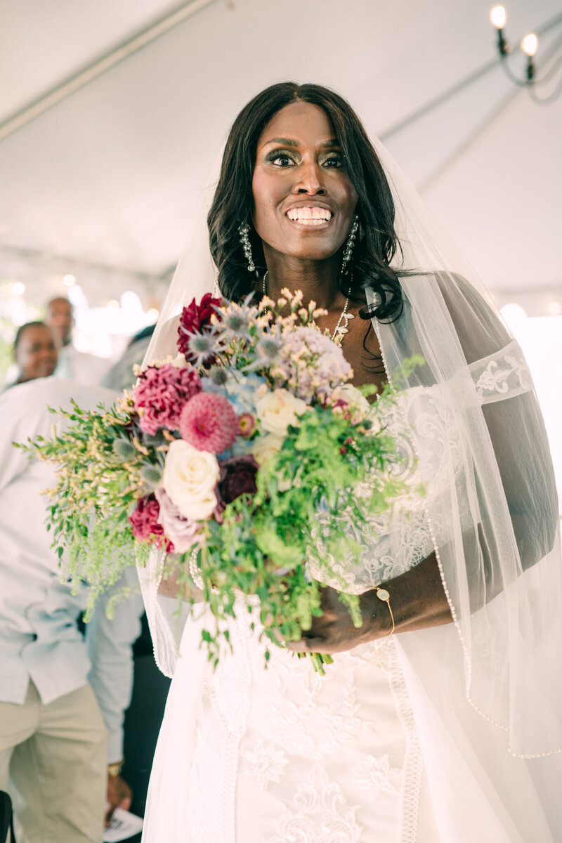 Smiling bride holding colorful bouquet