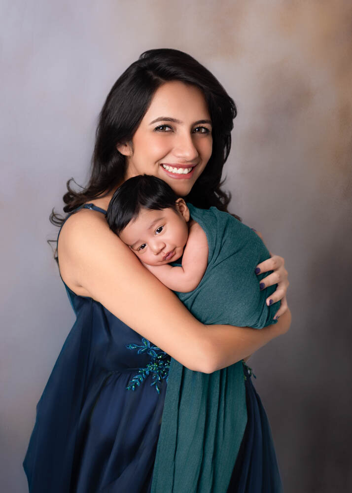 mother-hugging-newborn-baby-blue-wrap