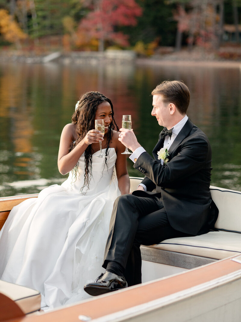 Black and white image of bride and groom holding hands with their arms in the air in front of their wedding reception stage and cold sparks in Martha's Vineyard
