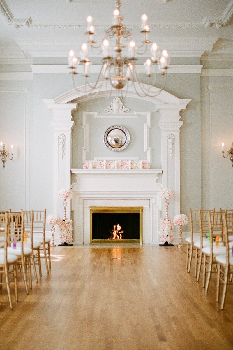 Reception room decorated  with gas fireplace ,  guest chairs and chandelier