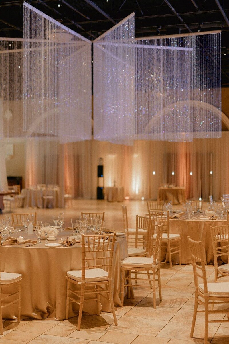 A joyful bride and groom dancing together during their reception, surrounded by friends and family.