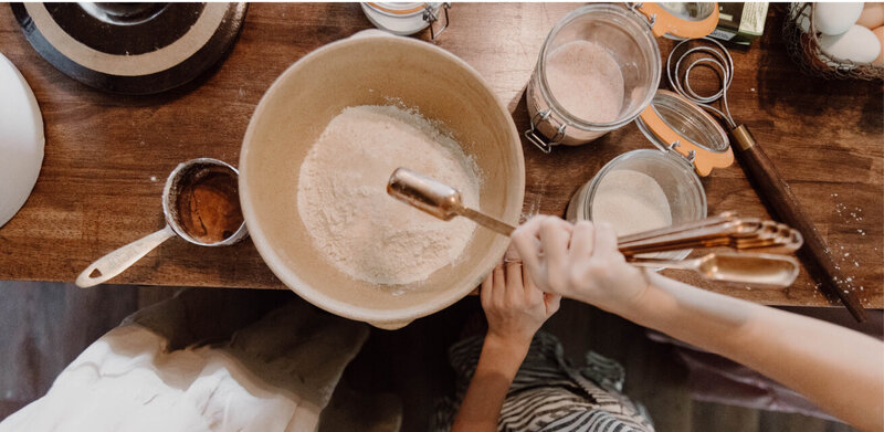 Children helping add ingredients to the baking bowl