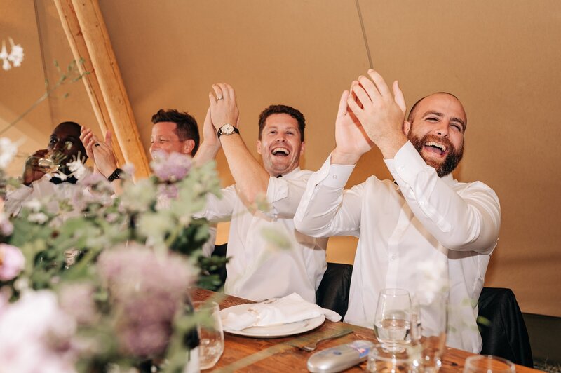 a bridal party claps and cheers in an elements tipi in christchurch wedding