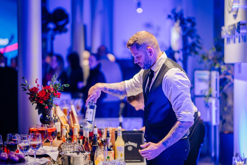 Bartender mixing drinks at private corporate event.