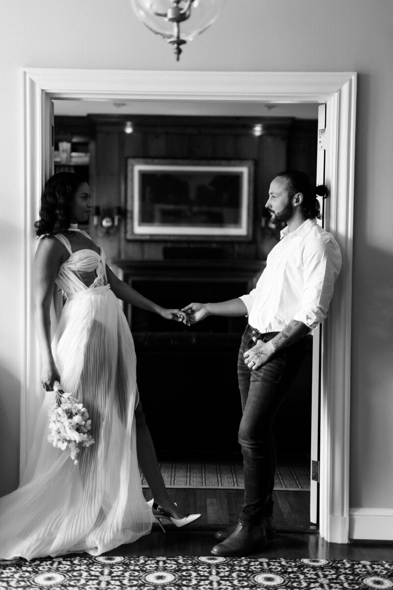 Kaitland and Kramer share a romantic kiss at their sweetheart table at Boxwood Estate. Surrounded by elegant floral arrangements and soft candlelight, the couple smiles as they embrace in a moment of joy and love. Kaitland wears a stunning white wedding gown, and Kramer is dressed in a classic suit. The intimate setting, with the estate’s beautiful decor and warm lighting, adds to the magic of their celebration.