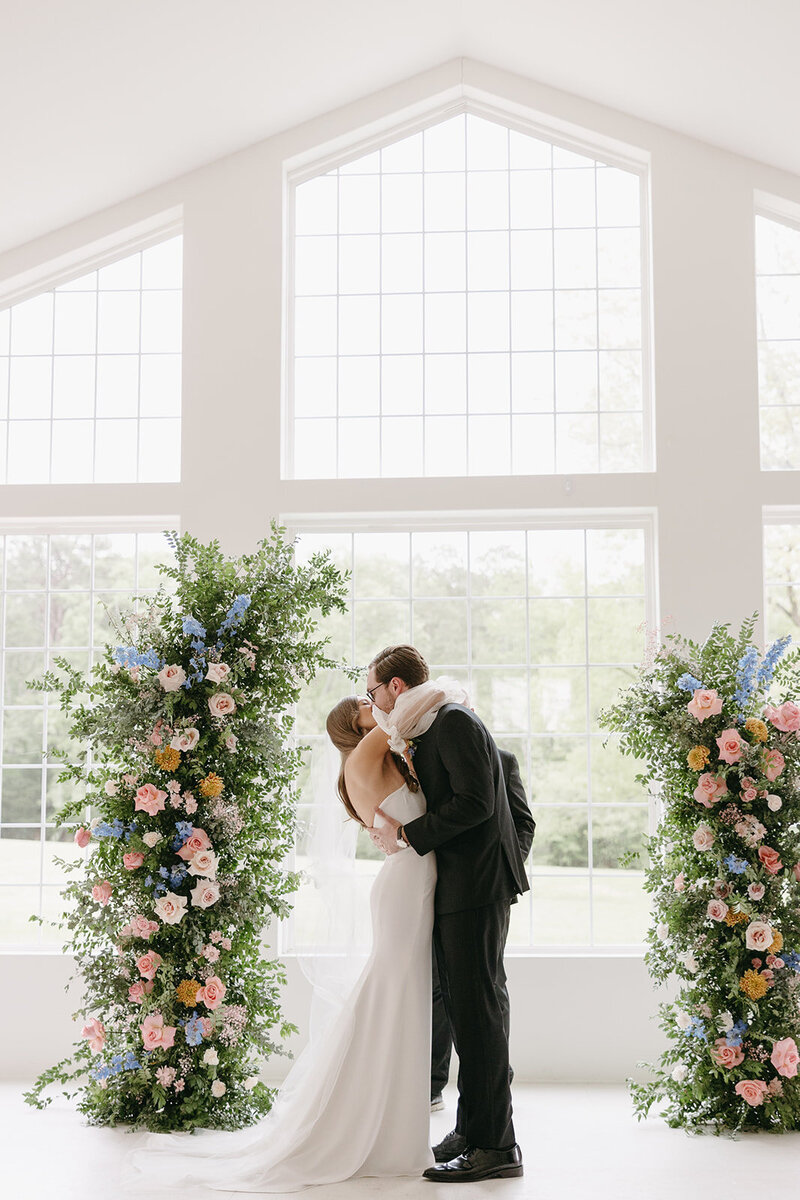 bride and groom kiss at the altar