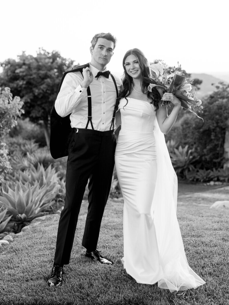 bride and groom during candid moment on their wedding day running through the vines