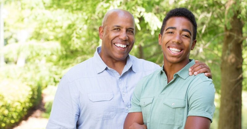 Teen boy with his father smiling and enjoying the outdoors.
