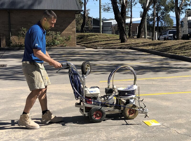 Rapid Epoxy & Linemarking worker in uniform prepping equipment to commence line marking