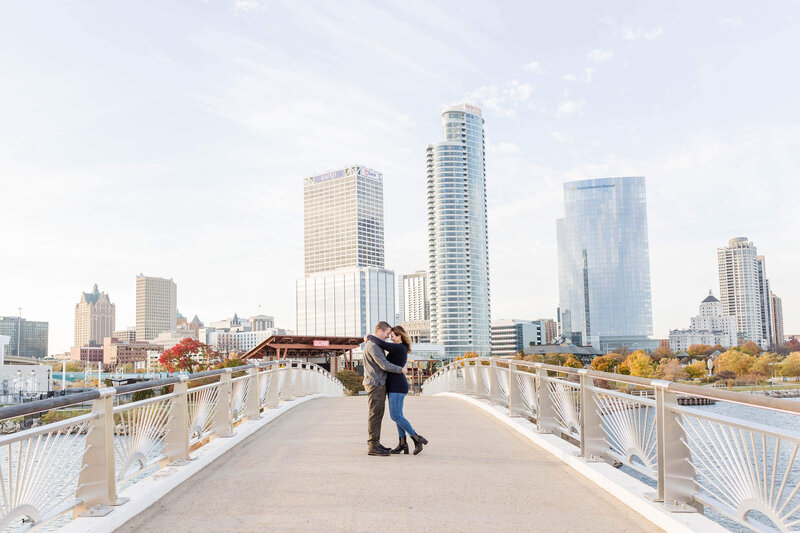 Engaged couple embracing in front of Milwaukee, Wisconsin skyline in the Fall, Milwaukee Engagement Photographer