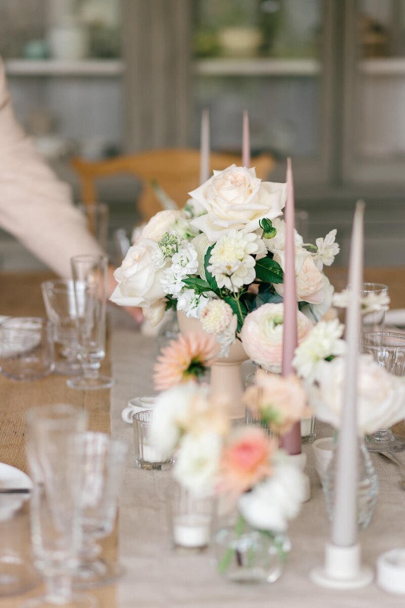 A round wedding breakfast table with a large ethereal design of trees in the centre and white hydrangeas at the base of the design for this Cornwall marquee wedding