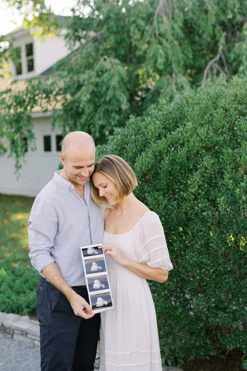 Expecting mother and father holding ultrasound photos